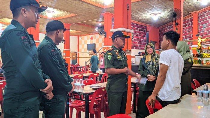 Petugas Satpol PP dan WH Aceh Besar, melakukan sosialisasi kepada pedagang perihal SE Gubernur Aceh, di Lambaro, Aceh Besar, Jumat (11/8/2023) malam.