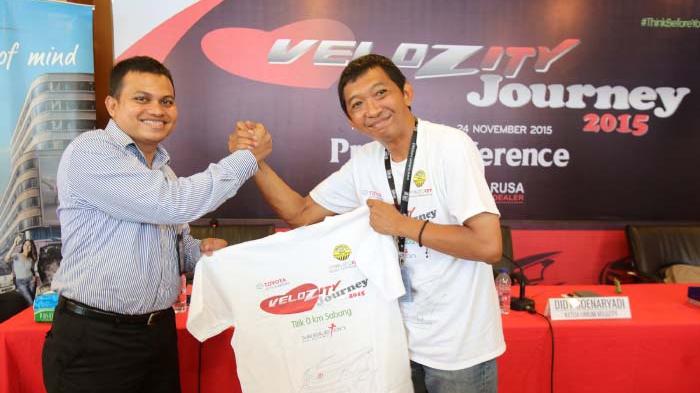 Ketua Umum Velozity, Didy Soenaryadi memberikan baju Velozity kepada Sales Manager PT Dunia Barusa, Azhar saat tiba di Dealer Toyota Aceh PT Dunia Barusa, Banda Aceh, Rabu (18/11). SERAMBI/BUDI FATRIA