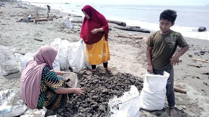 Warga mengumpulkan ceceran batu bara di kawasan Pantai Peunaga Rayeuk, Kecamatan Meureubo, Aceh Barat, Selasa (14/3/2023).
