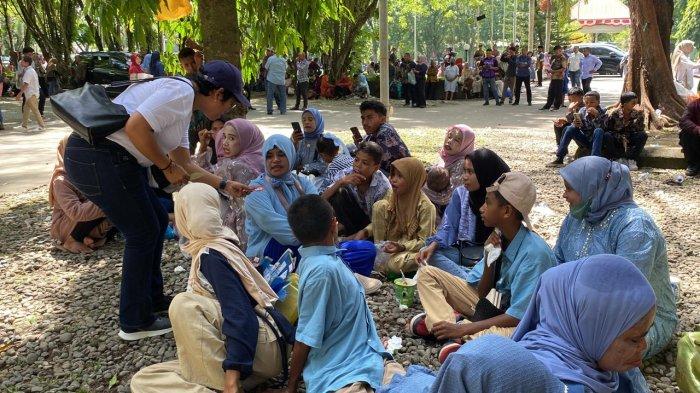 Ketua LBH Fakultas Hukum Unpatti, Mahrita Aprilya Lakburlawal saat membagikan brosur dan stiker kepada warga yang hadir saat wisuda Universitas Pattimura Ambon, Selasa (10/12/2024).
