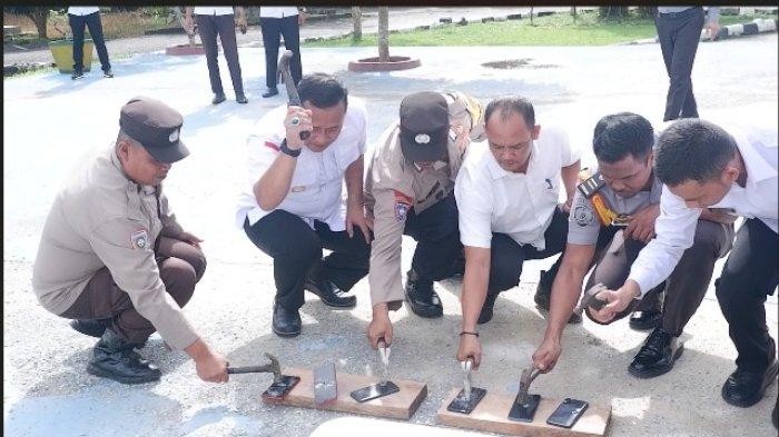 PEMUSNAHAN PONSEL HASIL SITAAN - Petugas Lembaga Pemasyarakatan (Lapas) Narkotika Kelas IIA Pangkalpinang, Rabu (9/7/2025), memusnahkan ponsel hasil sitaan. Pemusnahan barang sitaan dari hasil penggeledahan blok hunian warga binaan melalui razia rutin dan insidental sepanjang tahun 2024 hingga Juni 2025 tersebut menunjukkan komitmen nyata dalam menjaga keamanan dan ketertiban di lapas. Total ada 365 ponsel yang dimusnahkan.