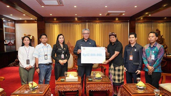 PEMBERIAN SANTUNAN - Pemkab Gianyar saat memberikan santunan kematian pada ahli waris mendiang Bape Sidja, Jumat (19/7).