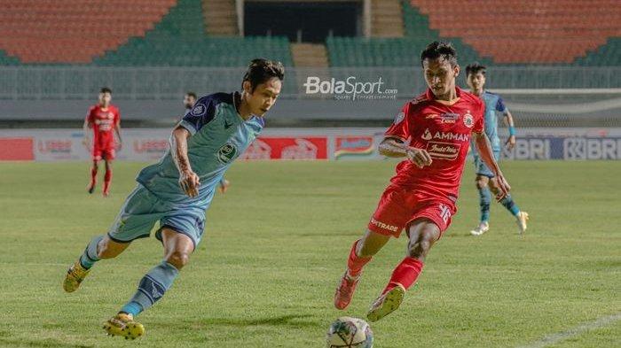 Bek sayap kanan Persela Lamongan, Ahmad Birrul Walidain (kiri), sedang berebut bola dengan pemain Persija Jakarta, Osvaldo Haay (kanan), dalam laga pekan keempat Liga 1 2021 di Stadion Pakansari, Bogor, Jawa Barat, 24 September 2021.