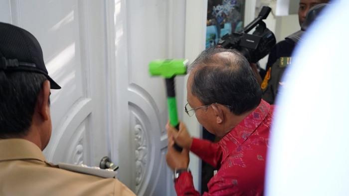 PEMBONGKARAN - Gubernur Bali Wayan Koster menggunakan palu membongkar salah satu pintu masuk akses penginapan mewah bernama Morabito Art Cliff yang berada di kawasan Pantai Bingin, Pecatu, Kuta Selatan, Badung, Bali, Senin 21 Juli 2025 pagi.
