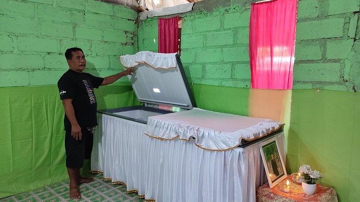 Made Suki Arsawan melihat jenazah anaknya yang kini telah disemayamkan di rumah duka, Rabu (17/1). Jenazah korban pengeroyokan ini terpaksa dipulangkan naik pikap, lantaran keterbatasan ekonomi keluarga.