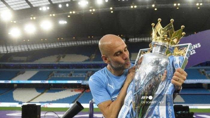 Manajer Manchester City Pep Guardiola merayakan dengan trofi Liga Premier