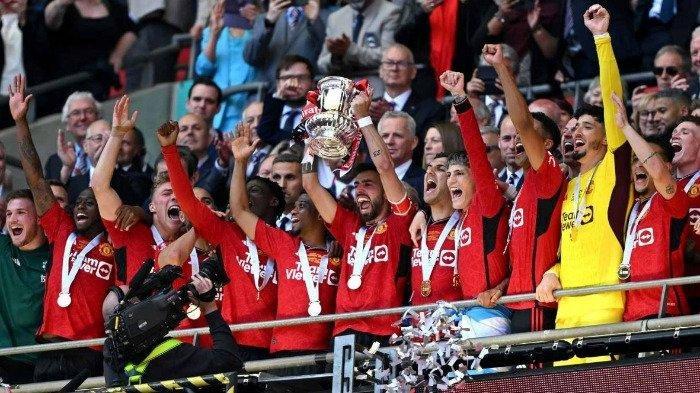 Manajer Manchester United asal Belanda Erik ten Hag mengangkat trofi untuk merayakan kemenangan mereka di penghujung pertandingan sepak bola final Piala FA Inggris antara Manchester City dan Manchester United di stadion Wembley, London, pada 25 Mei 2024. Manchester United menang 2 - 1 melawan Manchester City. Ben Stansall / AFP