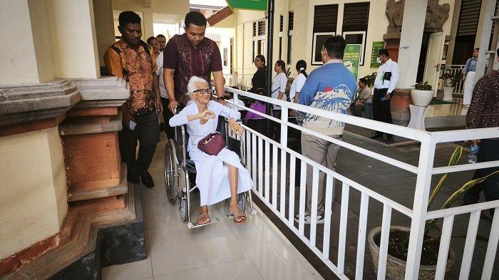 KURSI RODA - Nenek berusia 93 tahun Ni Nyoman Reja asal Jimbaran saat mengikuti sidang di PN Denpasar menggunakan kursi roda, pada Kamis 22 Mei 2025.