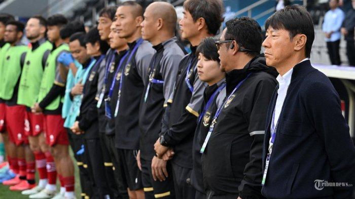 Pelatih Indonesia asal Korea Selatan Shin Tae-yong (kanan) berdiri bersama anggota timnya sebelum dimulainya pertandingan sepak bola Piala Asia AFC Qatar 2023 antara Australia dan Indonesia di Stadion Jassim bin Hamad di Doha. Minggu (28 Januari 2024). (HECTOR RETAMAL / AFP)