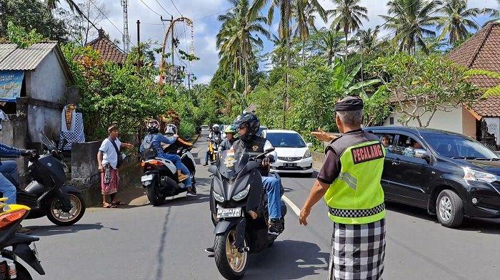 Pecalang saat menginformasikan ihwal penundaan wisatawan pada pengunjung yang telanjur ke Penglipuran. Minggu (6/8/2023)