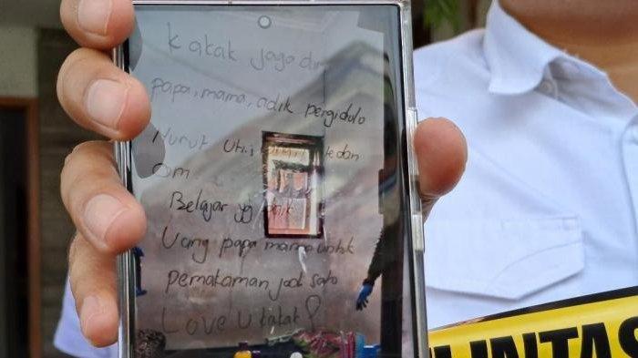 Surat wasiat yang ditulis korban di meja kaca rias dalam kamar, kasus bunuh diri sekeluarga di Pakis, Kabupaten Malang.