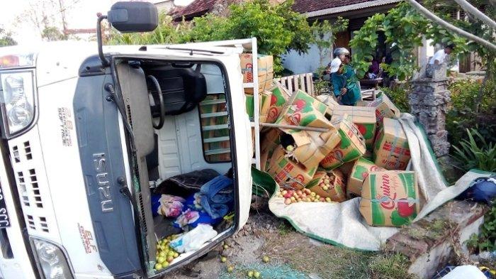 Truk putih bermuatan buah apel saat mengalami lakalantas out of control (OC) di jalur tengkorak Jalan Raya Denpasar-Gilimanuk KM 100, Banjar/Desa Banyubiru, Kecamatan Negara, Jembrana, Jumat 28 Juli 2023. Truk tersebut terguling ke kiri lantaran pagi.