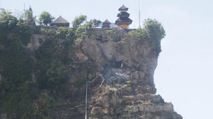 Sejumlah pekerja tengah mengerjakan penanganan keretakan tebing di bawah Pura Uluwatu.