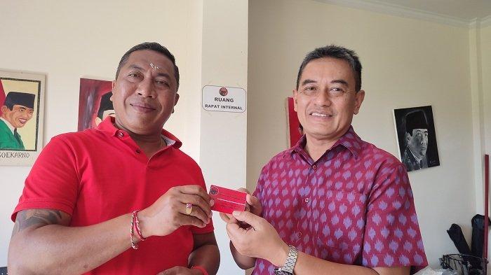 Nyoman Arya Astawa atau yang akrab disapa Mang Dauh (kiri) menunjukan KTA DPC PDI Perjuangan Buleleng, Selasa (30/4). Mang Dauh mendaftarkan diri sebagai bakal calon Wakil Bupati Buleleng lewat PDI Perjuangan