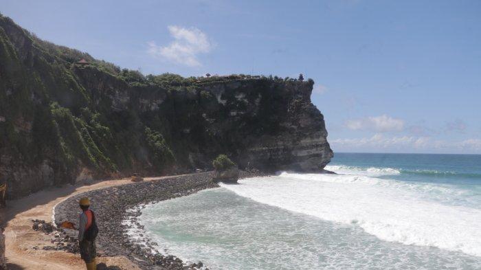 TEBING RETAK - Sejumlah pekerja mengerjakan penanganan keretakan tebing di bawah Pura Uluwatu, Kecamatan Kuta Selatan, Kabupaten Badung, kemarin. Proyek ini dipastikan molor karena progres pengerjaan baru di angka 70 persen.