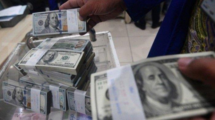 UANG DOLAR - Petugas menata tumpukan uang dolar AS di Cash Center Bank Mandiri, Jakarta, baru-baru ini. Beban utang pemerintah semakin berat, ekonom ingatkan utang terselubung.