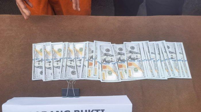 Barang bukti pecahan uang palsu US$ 100 sebanyak 58 lembar.
