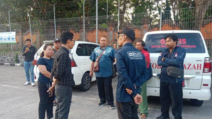 MENUNGGU - Petugas Dinas Tenaga Kerja dan Perindustrian Kabupaten Jembrana bersama pihak keluarga saat menunggu kedatangan jenazah I Made Dwi Putrayasa di Bandara Internasional I Gusti Ngurah Rai, Badung, Bali, Kamis (18/7) sore.