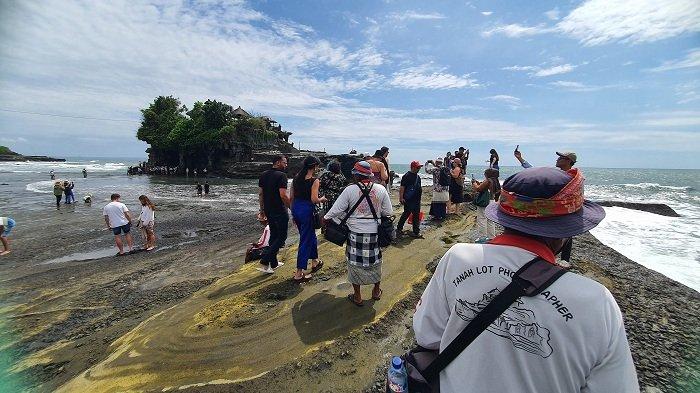 WISATAWAN – Sejumlah wisatawan menikmati pemandangan DTW Tanah Lot, Kecamatan Kediri, Kabupaten Tabanan, Senin (30/12). Di ujung pergantian tahun jumlah kunjungan meningkat tajam mencapai 8 ribu wisatawan per hari.