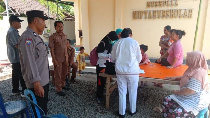 KERACUNAN MAKANAN - Petugas kesehatan memberi penanganan kepada warga Desa Tegal Badeng Barat, Kecamatan Negara, Jembrana yang keracunan makanan, Senin (30/0). 