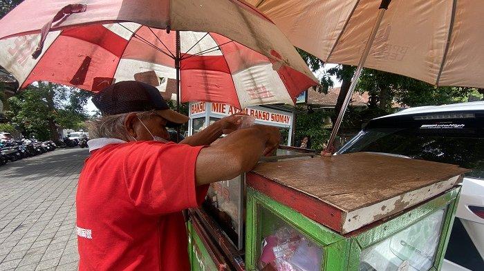 Meskipun masuk musim penghujan, tak menyurutkan semangat Murad untuk berjualan es teh. 
