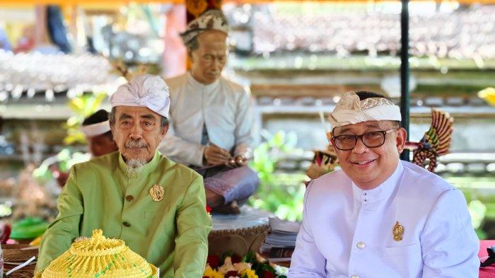Ari Dwipayana (kanan) dan Ida Dalem Semara Putra berpose di depan patung Anak Agung Gde Oka Kerebek di Puri Kauhan Ubud.