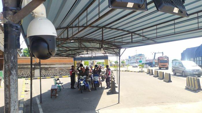 Pengendara sepeda motor melepaskan helm dan masker saat menjalani kegiatan pemeriksaan orang, kendaraan dan barang di pintu masuk Bali via Pelabuhan Gilimanuk Jembrana, Bali.