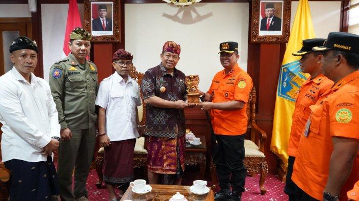 CINDERAMATA - Pj Gubernur Bali Sang Made Mahendra Jaya menerima cinderamata dari Kepala Kantor Basarnas Bali I Nyoman Sidakarya yang bertemu beserta jajaran di Ruang Rapat Adhi Sabha Kantor Gubernur di Denpasar, Kamis (26/10). 