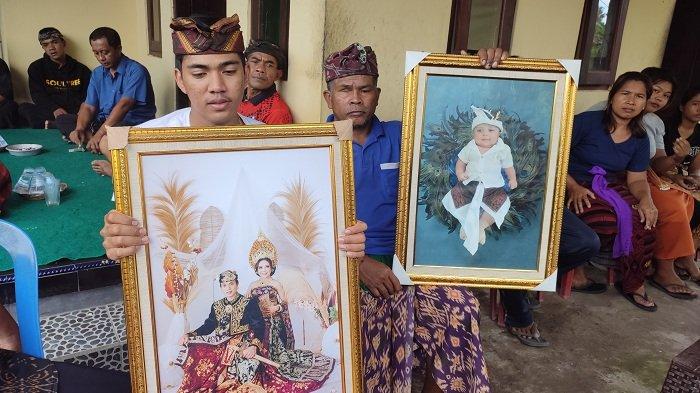 Mahendra (baju putih) menunjukan foto semasa hidup I Made Arisanjaya bersama istrinya Komang Novi serta anaknya Putu Gede Arta Dharma Sankara, Selasa (7/5).