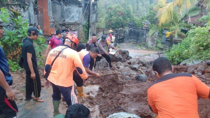 Tim BPBD Buleleng dibantu warga saat melakukan upaya evakuasi material longsor. Minggu (10/11/2024)
