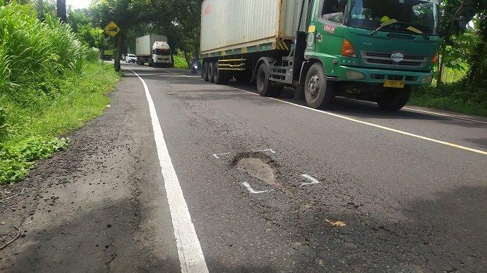 JALAN BERLUBANG - Salah satu titik jalan berlubang yang berpotensi membahayakan pengendara di Jalur Nasional Jalan Raya Denpasar-Gilimanuk wilayah Kecamatan Negara, Jembrana, Rabu (12/3). BBPJN sebut perbaikan jalan berlubang selesai H-10 Lebaran atau 20-21 Maret 2025 mendatang.