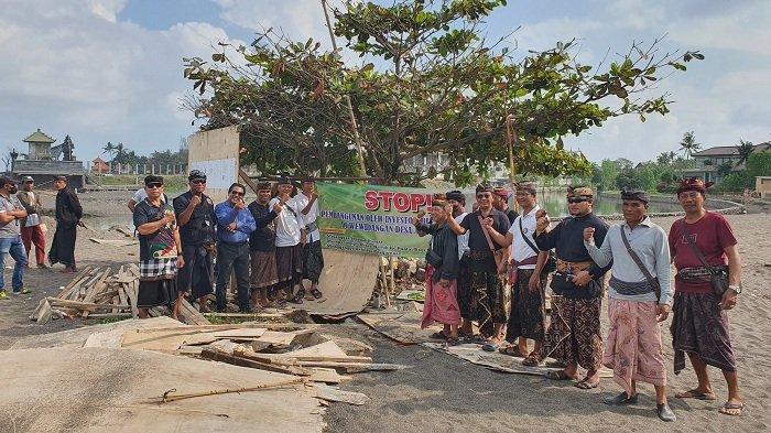 Sejumlah Krama desa adat, bersama bendesa adat dan tokoh masyarakat lainnya saat melakukan penolakan dengan membentangkan baliho di Pantai Lima pada Selasa 18 Juni 2024.