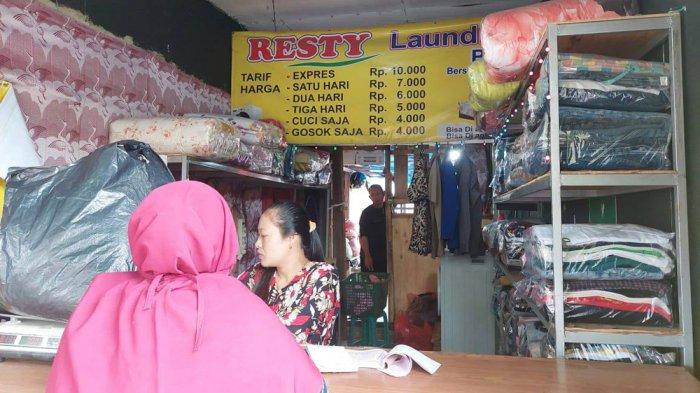 Warga bekerja di cabang laundry yang dioperasikan oleh Abdurrohim
