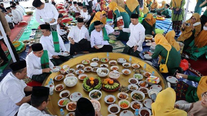 Wali Kota Pangkalpinang, Maulan Aklil didampingi Kepala Kantor Kemenag setempat Firmantasi saat menyantap makanan dari dulang raksasa saat acara nganggung HSN di Halaman Gedung Tudung Saji Kantor Wali Kota Pangkalpinang, Sabtu (22/10/2022).