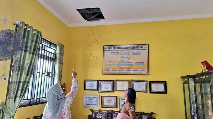 Guru SDN 62 Kota Pangkalpinang saat menunjukkan kondisi plafon yang dijebol pelaku pencurian laptop, Selasa (14/05/2024).