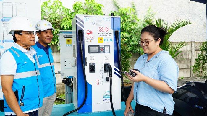 Plt. Direktur Utama PLN Haleyora Power, Isral (kiri) ketika menyapa seorang pelanggan yang sedang melakukan pengisian daya kendaraan listriknya di rest area KM 6 Jakarta-Cikampek.