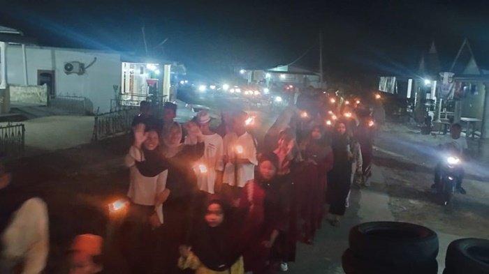 PAWAI OBOR -- Ratusan warga bersama Santri dan Santriwati TPA Inayatullah Kampung Bantam mengikuti kegiatan pawai obor dengan berkeliling kampung membawa obor terbatas dari bambu. Pawai obor dilaksanakan di Kampung Bantam, Kecamatan Belinyu, Kabupaten Bangka, Kamis (28/2/2025)