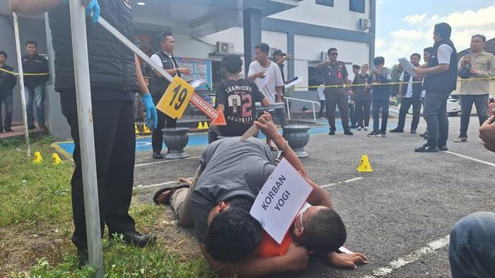 PENGANIAYAAN BERAT -- Rekonstruksi kasus penganiayaan berat yang menyebabkan tewasnya korban P (22) di Desa Batu Beriga, Kecamatan Lubuk Besar, Bangka Tengah yang berlangsung di halaman Mako Polres Bangka Tengah, Kamis (24/7/2025).