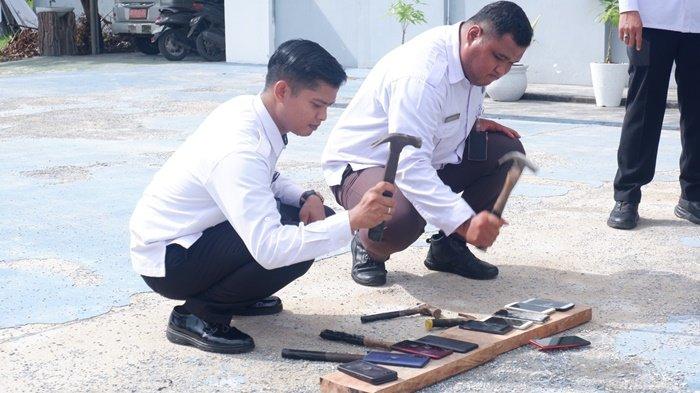 PEMUSNAHAN HANDPHONE -- Kalapas Narkotika Kelas IIA Pangkalpinang, Maman Herwaman beserta jajarannya, ketika melakukan pemusnahan handphone ilegal dihalaman Lapas, Rabu (9/7/2025)