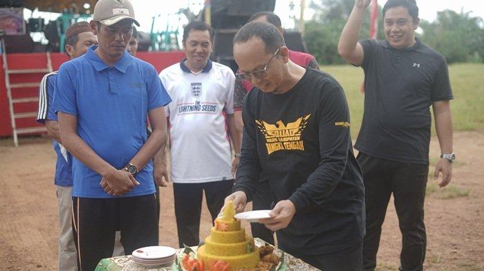 Bupati Bangka Tengah, Algafry Rahman memotong tumpeng bersama Kepala Desa Melabun