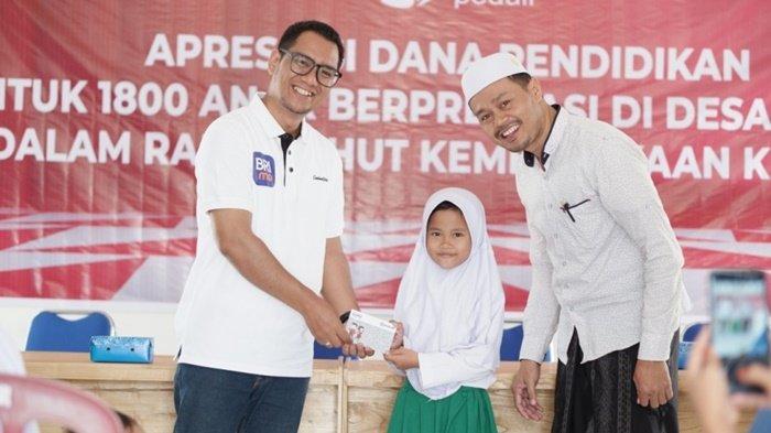 Pemimpin Cabang BRI Pleihari, Muhammad Aqbar, saat menyerahkan bantuan kepada seorang murid Madrasah Ibtidaiyah berprestasi di Desa BRILian, yakni Desa Durian Bungkuk, Kecamatan Batu Ampar, Kabupaten Tanah Laut, Provinsi Kalimantan Selatan, 25 September 2023.