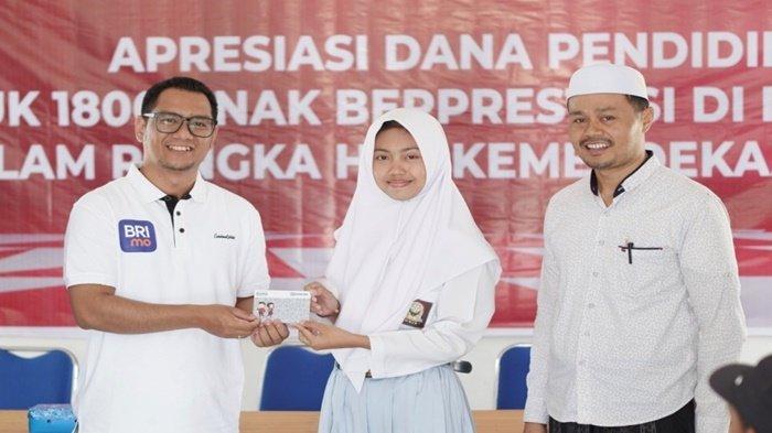 Pemimpin Cabang BRI Pleihari, Muhammad Aqbar, saat menyerahkan bantuan kepada pelajar berprestasi setingkat SMA di Desa BRILian, yakni Desa Durian Bungkuk, Kecamatan Batu Ampar, Kabupaten Tanah Laut, Provinsi Kalimantan Selatan, 25 September 2023.