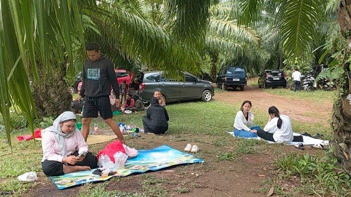 BERSANTAI DI BAWAH SAWIT - Pengunjung bersantai di bawah pepohonan kelapa sawit di lokasi wisata Pemandian Mekar Banyu Batuah di Desa Sungaibakar.