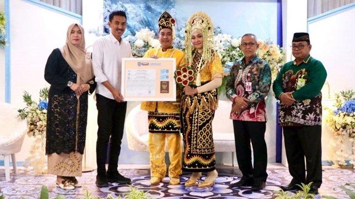 Pengantin dan Bupati Banjar H Saidi Mansyur menunjukkan dokumen dalam Pogram Pakulih Anam, Rabu (11/10/2023).