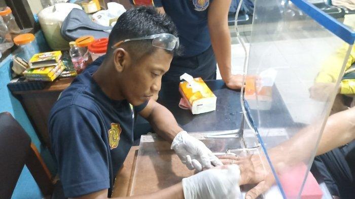 Cincin batu akik di jari tengah Tom, seorang pria asing yang datang ke Kantor Damkar Palangkaraya untuk minta dilepaskan cincin yang terpasang dijarinya.