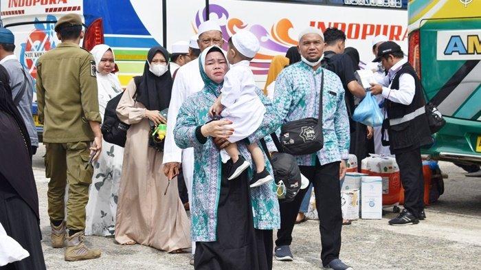 Jemaah haji perempuan yang baru tiba dari Tanah Suci, menggendong seorang bocah yang ikut menyambu kedatangannya di halaman Masjid Al-Mukarram Amanah, Kota Kuala Kapuas, Kabupaten Kapuas, Provinsi Kalimantan Tengah, Kamis (13/7/2023).