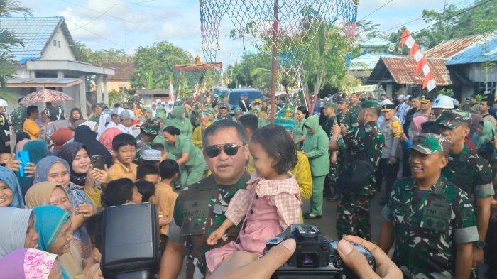 Foto Kepala Staf Angkatan Darat (KSAD),  Jenderal TNI Maruli Simanjuntak,menggendong salah satu anak di Desa Karang Rejo, saat penyambutan TNI berpangkat jendral tersebut, Jum'at (7/6/2024)