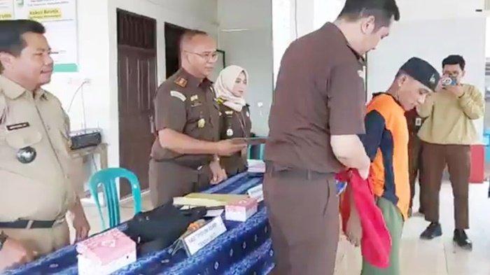 Kepala Seksi Pidana Umum Kejaksaan Negeri (Kejari) Tanah Laut, Harry Fauzan, melepaskan rompi tahanan pada Bahrani setelah sidang Restorative Justice yang dipimpin Kajari, Teguh Imanto, di Rumah RJ di Aula Kantor Desa Bumijaya,  Kecamatan Pelaihari, Kabupaten Tanah Laut, Provinsi Kalimantan Selatan, Senin (6/11/2023).