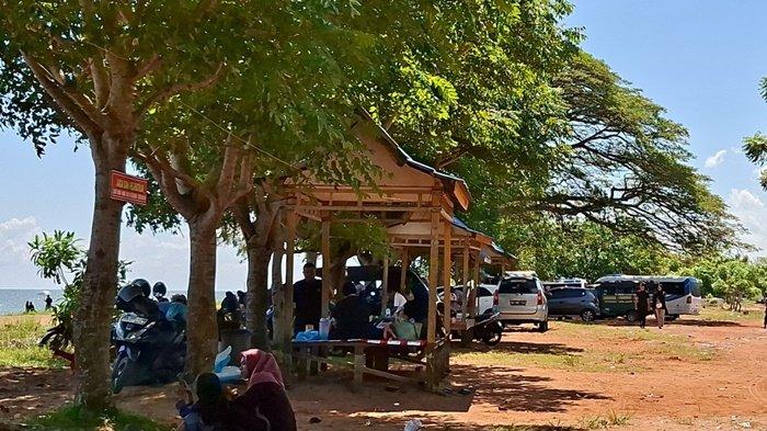 LOKASI PARKIR - Kendaraan bermotor pengunjung parkir di bawah pepohonan yang teduh di Pantai Tabanio, Kamis (7/4/2025).