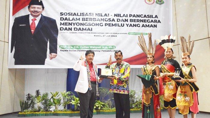 Kepala BPIP RI Prof. Drs. KH Yudian Wahyudi, MA, Ph.D menyerahkan Plakat kepada Plt Bupati Kapuas HM Nafiah Ibnor yang dalam hal ini diwakili Staf Ahli Bidang Pemerintahan, Hukum dan Politik Yunabut, dalam Seminar Pancasila tentang Aktualisasi Nilai-nilai Pancasila dalam Berbangsa dan Bernegara Menyongsong Pemilu yang Aman dan Damai, bertempat di Gedung Pertemuan Manggatang Tarung, Kota Kuala Kapuas, Kamis (27/7/2023).
